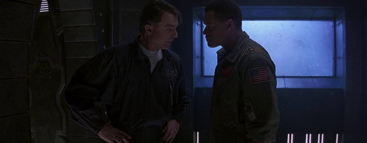 Still from Event Horizon. Laurence Fishburne & Sam Neill stand in a dark, claustrophobic spaceship interior.